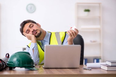 Tatilde kahve içen yorgun genç bir mimar.