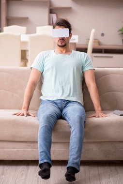 Evde sanal gözlük takan genç bir öğrenci.