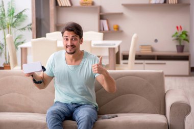 Evde sanal gözlük takan genç bir öğrenci.