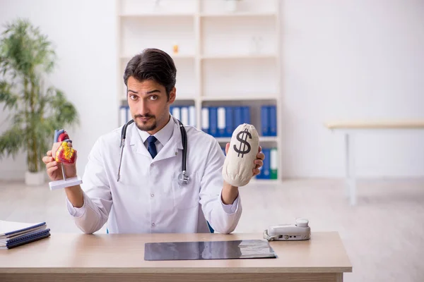 Junge männliche Arzt Kardiologe hält Monebag — Stockfoto