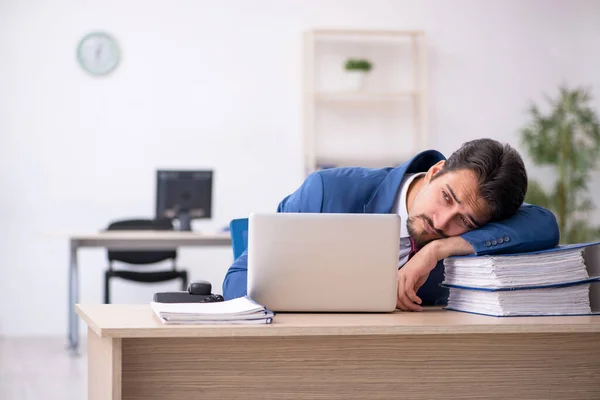 Jovem funcionário masculino infeliz com excesso de trabalho no escritório — Fotografia de Stock