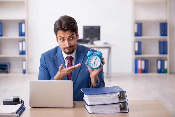 Joven empleado masculino en concepto de gestión del tiempo — Foto de Stock