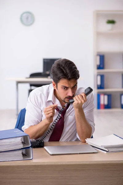 Joven empleado masculino descontento con el trabajo excesivo en la oficina — Foto de Stock