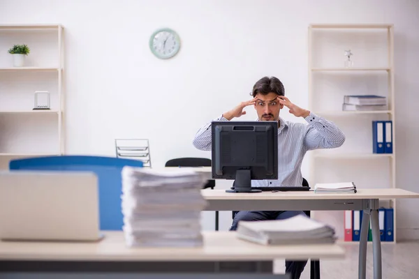 Jonge mannelijke werknemer en te veel werk op kantoor — Stockfoto