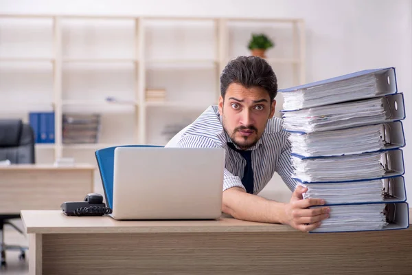 Junge männliche Mitarbeiter und zu viel Arbeit im Büro — Stockfoto