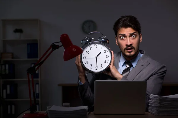 Ung manlig anställd som arbetar sent på kontoret — Stockfoto
