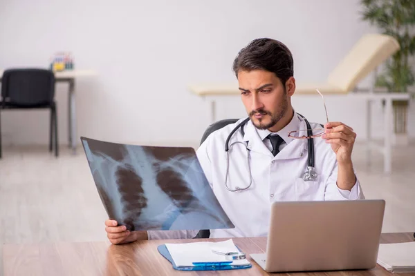 Jonge mannelijke arts radioloog zit in de kliniek — Stockfoto