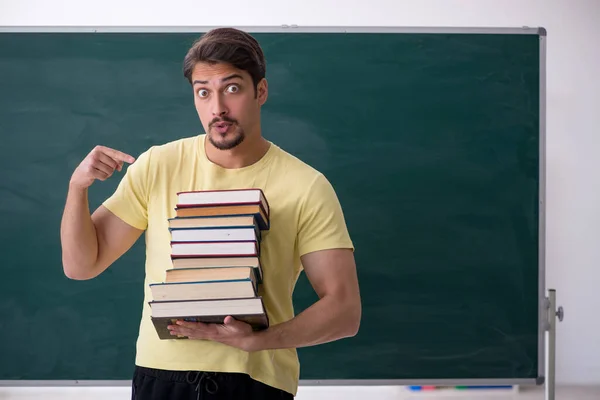 Young male student holding many books — Stock Photo, Image