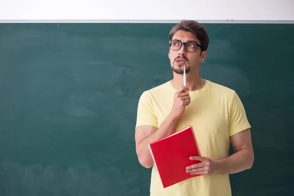 Joven estudiante masculino frente a pizarra — Foto de Stock