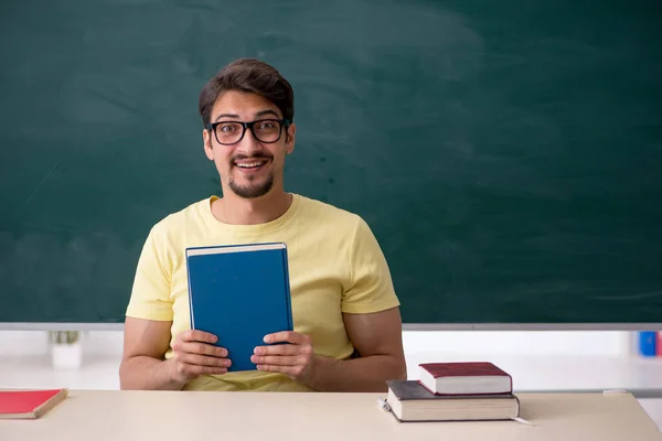 Mladý muž student před tabulí — Stock fotografie