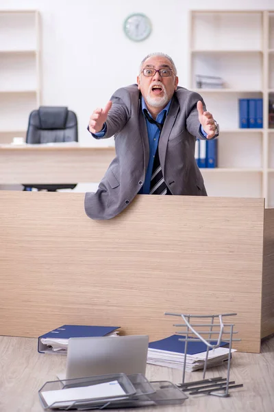 Oude mannelijke werknemer ongelukkig met overmatig werk in het kantoor — Stockfoto