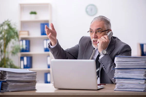 Alte männliche Angestellte unzufrieden mit exzessiver Arbeit im Büro — Stockfoto