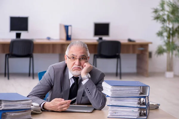 Öreg férfi alkalmazott elégedetlen a túlzott munka az irodában — Stock Fotó