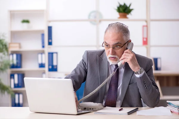 Old male employee unhappy with excessive work in the office — Stock Photo, Image