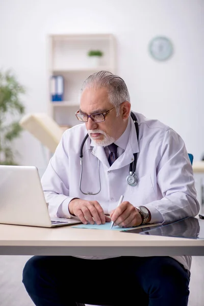 Hastanede çalışan yaşlı erkek doktor. — Stok fotoğraf