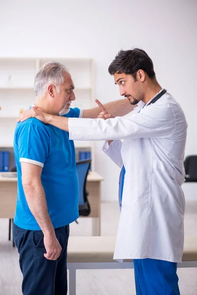 Yaşlı erkek hasta genç erkek doktoru ziyaret ediyor. — Stok fotoğraf