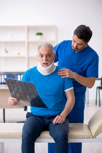 Alte männliche Patientin besucht junge männliche Ärztin — Stockfoto