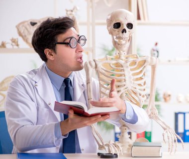 Çılgın profesör insan iskeleti üzerinde çalışıyor.