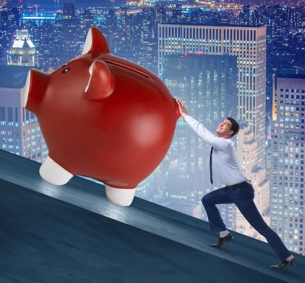 Man pushing piggybank uphill in business concept — Stock Photo, Image