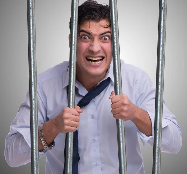 Young businessman behind the bars in prison — Stock Photo, Image