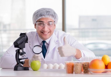 Besin uzmanı gıda ürünlerini laboratuarda test ediyor.