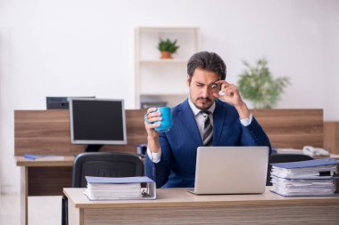 Molada kahve içen genç bir erkek.