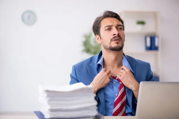 Junge männliche Angestellte unzufrieden mit exzessiver Arbeit im Büro — Stockfoto