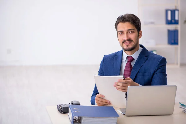 Jovem trabalhador masculino leitura de papel no local de trabalho — Fotografia de Stock