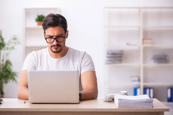 Ung manlig student anställd på arbetsplatsen — Stockfoto