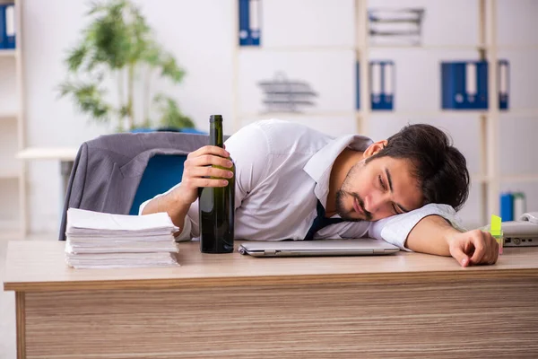 Jovem viciado em álcool empregado sentado no escritório — Fotografia de Stock