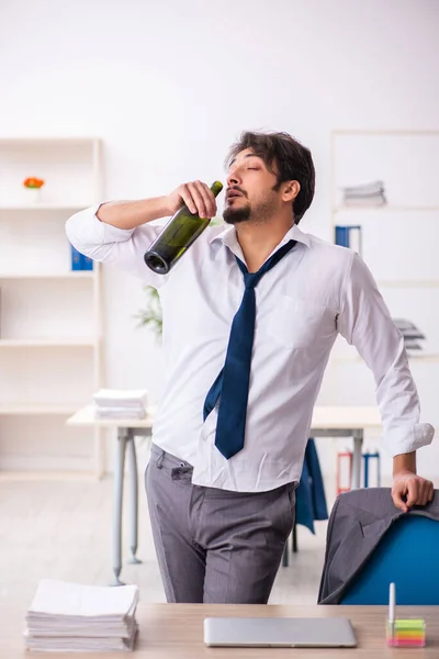 Empleado joven adicto al alcohol sentado en la oficina — Foto de Stock