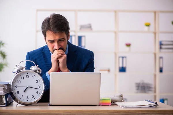 Joven empleado masculino en concepto de gestión del tiempo —  Fotos de Stock