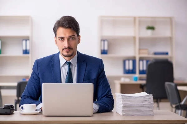 Joven empleado masculino y demasiado trabajo en la oficina —  Fotos de Stock