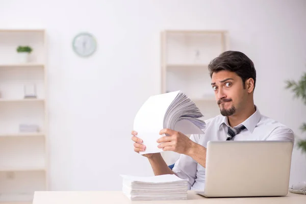 Joven empleado masculino descontento con el trabajo excesivo en la oficina —  Fotos de Stock