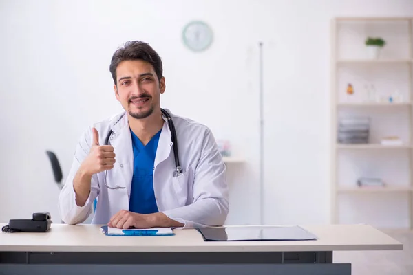 Ung manlig läkare som arbetar på kliniken — Stockfoto