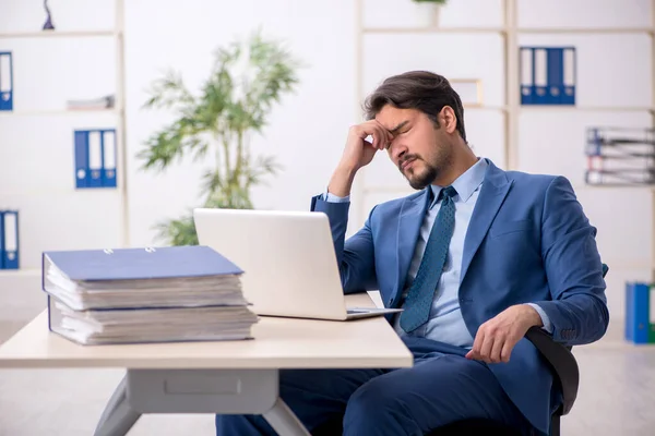 Jeune employé masculin et trop de travail au bureau — Photo