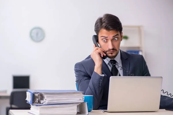 Jovem trabalhador masculino sentado no local de trabalho — Fotografia de Stock