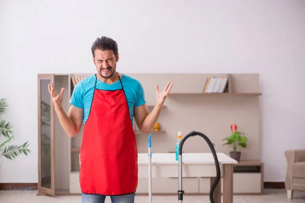 Jovem empreiteiro limpando a casa — Fotografia de Stock