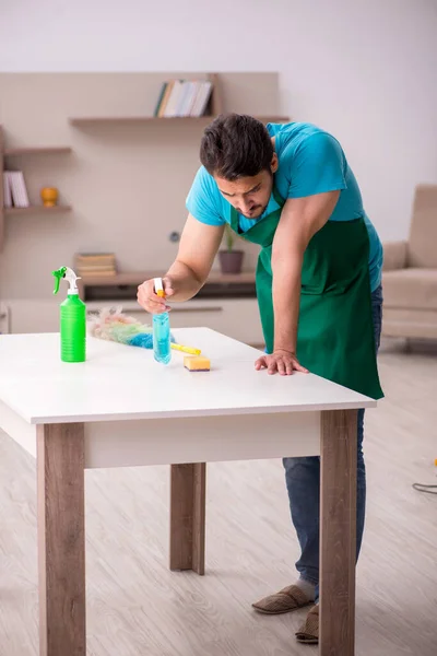 Jovem empreiteiro limpando a casa — Fotografia de Stock