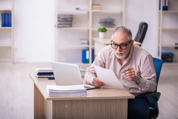 Ancien employé masculin travaillant sur le lieu de travail — Photo