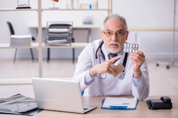 Klinikte çalışan yaşlı erkek doktor. — Stok fotoğraf