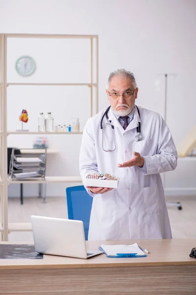 Viejo médico que trabaja en la clínica — Foto de Stock