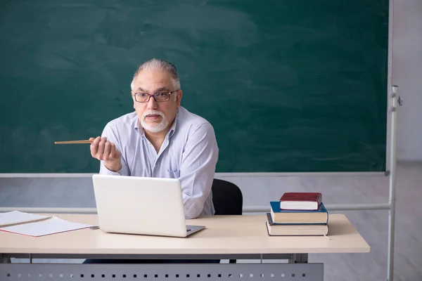 Starý učitel samec před zelenou tabulí — Stock fotografie