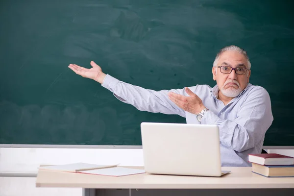 Oude mannelijke leraar voor het groene bord — Stockfoto