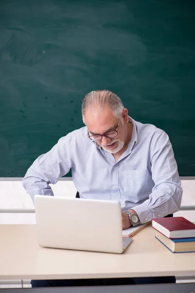 Viejo profesor delante del tablero verde — Foto de Stock