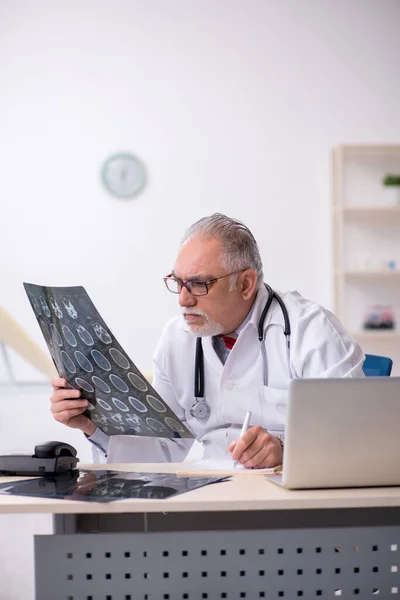 Gammal manlig röntgenläkare som arbetar på kliniken — Stockfoto