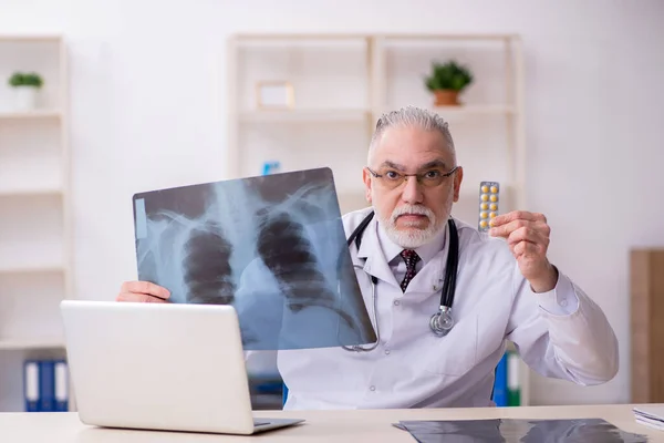 Gammal manlig röntgenläkare som arbetar på kliniken — Stockfoto