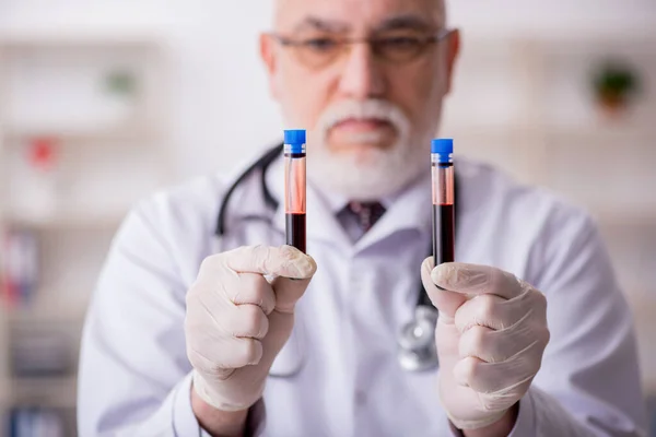 Homem velho médico hematologista que trabalha na clínica — Fotografia de Stock