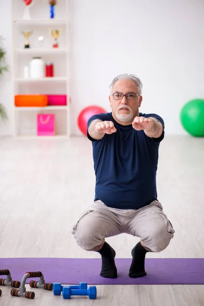 Starzec robi ćwiczenia sportowe w pomieszczeniu — Zdjęcie stockowe