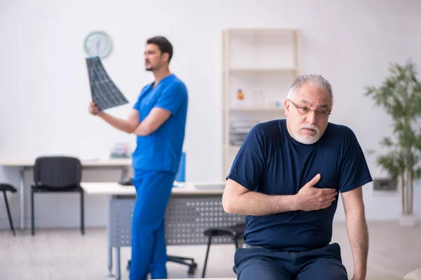 Viejo visitando joven médico radiólogo —  Fotos de Stock